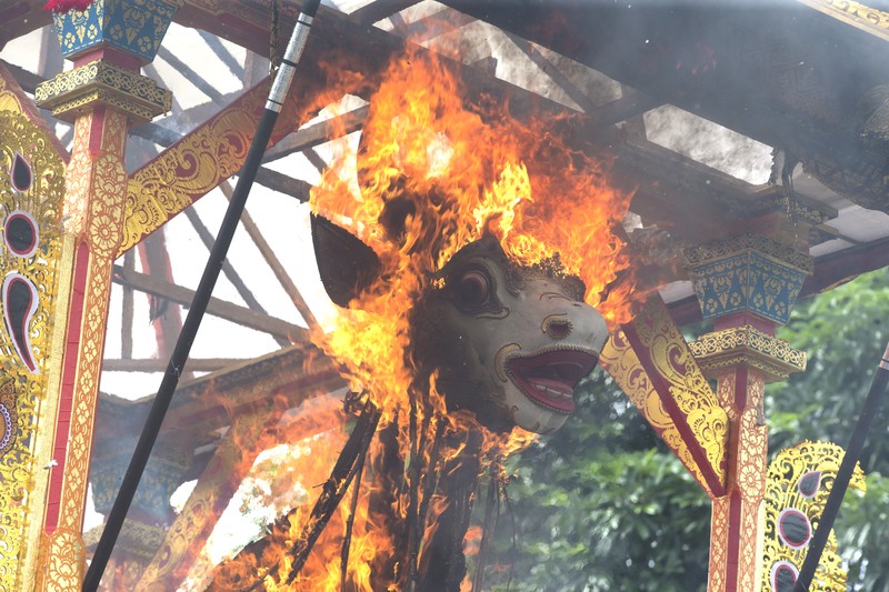 Indonesia Bali Royal Cremation A crowd of people watch a giant sarcophagus in the form of a bull during a procession of King Ida Cokorda Pemecutan XI in Denpasar, Bali, Indonesia on Friday, Jan. 21, 2022. (AP Photo/Firdia Lisnawati)