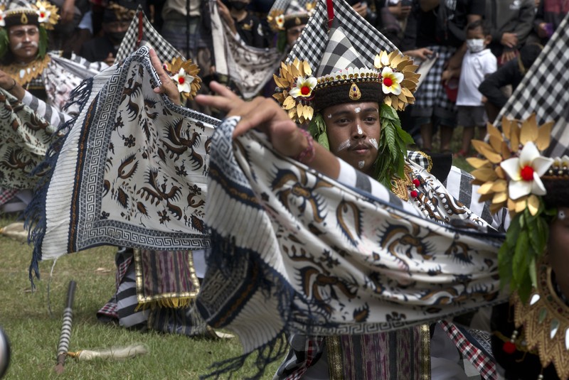 Indonesia Bali Royal Cremation A crowd of people watch a giant sarcophagus in the form of a bull during a procession of King Ida Cokorda Pemecutan XI in Denpasar, Bali, Indonesia on Friday, Jan. 21, 2022. (AP Photo/Firdia Lisnawati)