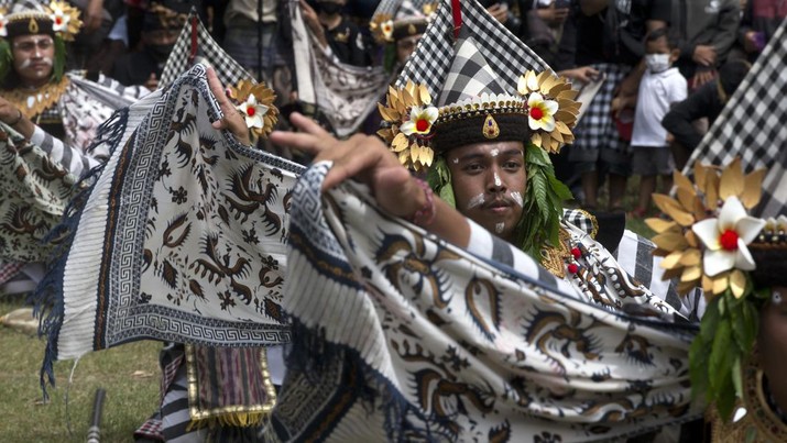 Dancers in Balinese traditional warrior's outfit pay their respect during a cremation ceremony of king Ida Cokorda Pemecutan XI in Denpasar, Bali, Indonesia on Friday, Jan. 21, 2022. (AP Photo/Firdia Lisnawati)