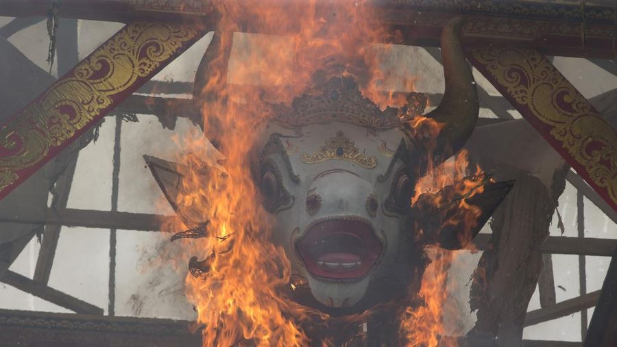 A crowd of people watch a giant sarcophagus in the form of a bull during a procession of King Ida Cokorda Pemecutan XI in Denpasar, Bali, Indonesia on Friday, Jan. 21, 2022. (AP Photo/Firdia Lisnawati)
