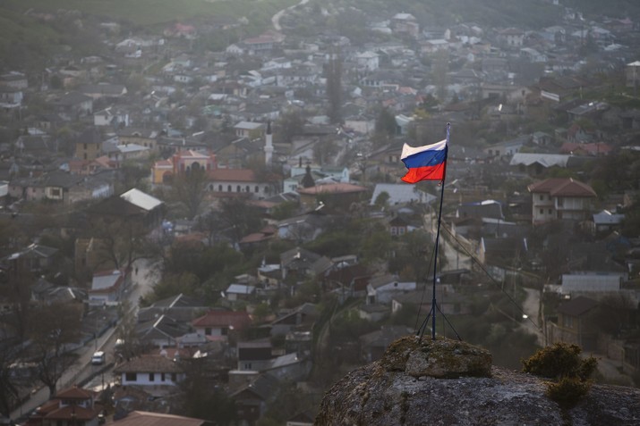 FILE - In this March 28, 2014 file photo, a Russian national flag flies on a hilltop near the city of Bakhchysarai, Crimea. The Group of Seven major industrialized countries on Thursday March 18, 2021, issued a strong condemnation of what it called Russia's ongoing “occupation” of the Crimean Peninsula, seven years after Moscow annexed it from Ukraine. (AP Photo/Pavel Golovkin, File)