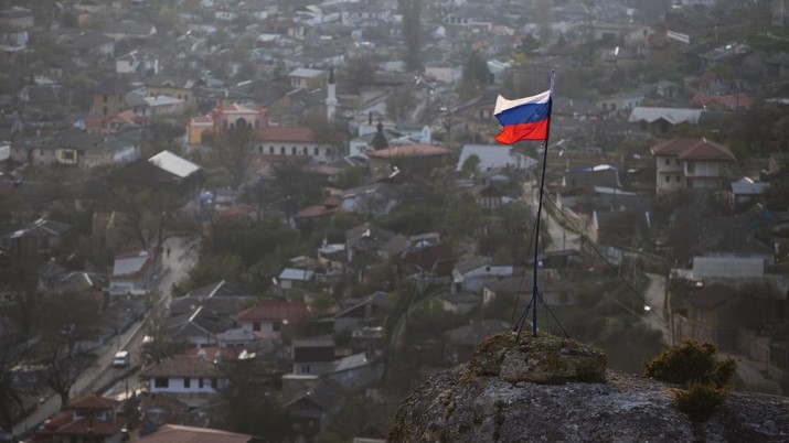 FILE - In this March 28, 2014 file photo, a Russian national flag flies on a hilltop near the city of Bakhchysarai, Crimea. The Group of Seven major industrialized countries on Thursday March 18, 2021, issued a strong condemnation of what it called Russia's ongoing “occupation” of the Crimean Peninsula, seven years after Moscow annexed it from Ukraine. (AP Photo/Pavel Golovkin, File)