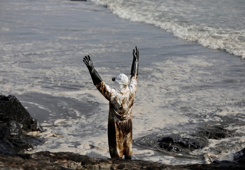 Otoritas setempat dan pekerja kilang La Pampilla, Peru, membersihkan tumpahan minyak di lepas pantai Ventanilla. Tumpahan minyak ini terjadi akibat gelombang tsunami yang dipicu letusan gunung api bawah laut di Tonga. (REUTERS/PILAR OLIVARES)