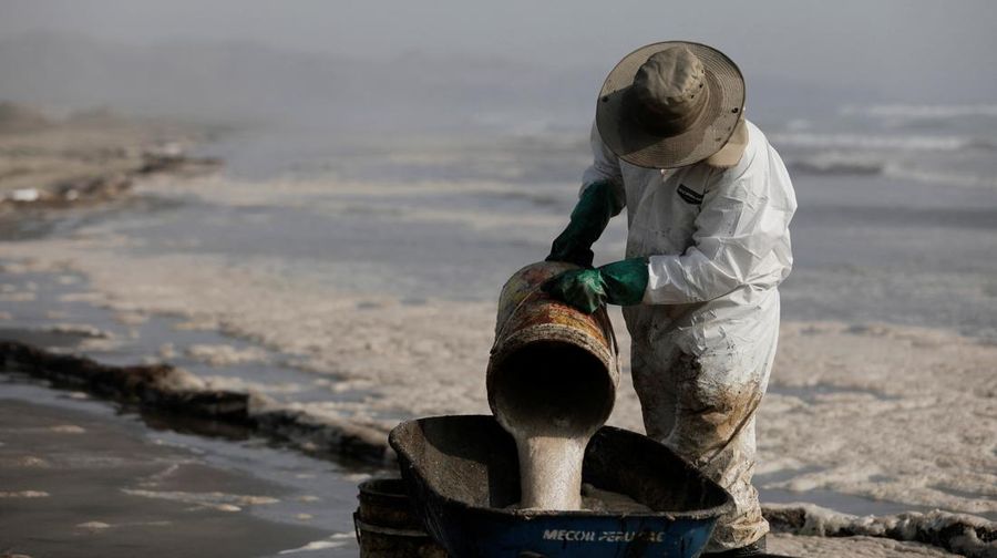 Otoritas setempat dan pekerja kilang La Pampilla, Peru, membersihkan tumpahan minyak di lepas pantai Ventanilla. Tumpahan minyak ini terjadi akibat gelombang tsunami yang dipicu letusan gunung api bawah laut di Tonga. (REUTERS/PILAR OLIVARES)