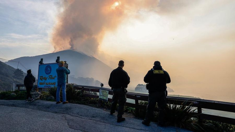 Mobil melintas saat api kebakaran Colorado membakar di sepanjang Highway 1 dekat Big Sur, California, Sabtu, 22 Januari 2022. (AP Photo/Nic Coury)