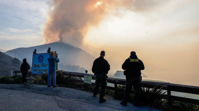 Mobil melintas saat api kebakaran Colorado membakar di sepanjang Highway 1 dekat Big Sur, California, Sabtu, 22 Januari 2022. (AP Photo/Nic Coury)