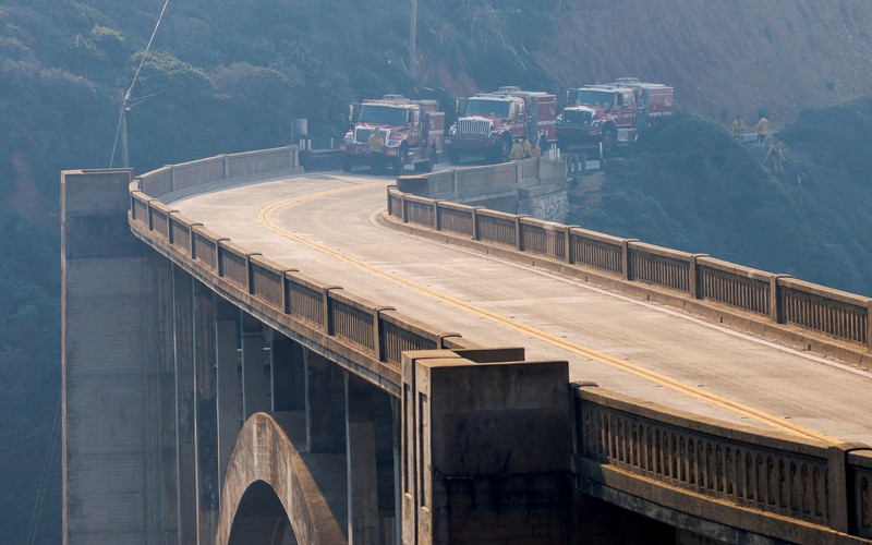 Mobil melintas saat api kebakaran Colorado membakar di sepanjang Highway 1 dekat Big Sur, California, Sabtu, 22 Januari 2022. (AP Photo/Nic Coury)