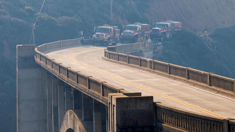 Mobil melintas saat api kebakaran Colorado membakar di sepanjang Highway 1 dekat Big Sur, California, Sabtu, 22 Januari 2022. (AP Photo/Nic Coury)