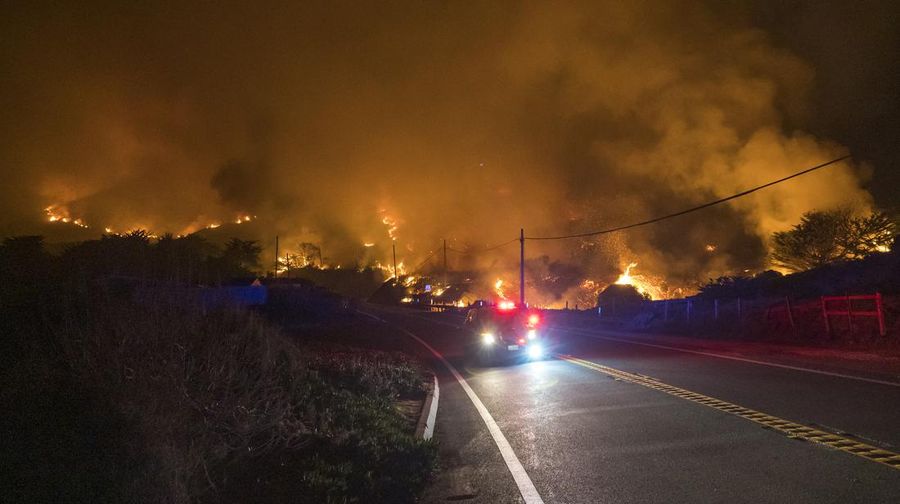 Mobil melintas saat api kebakaran Colorado membakar di sepanjang Highway 1 dekat Big Sur, California, Sabtu, 22 Januari 2022. (AP Photo/Nic Coury)