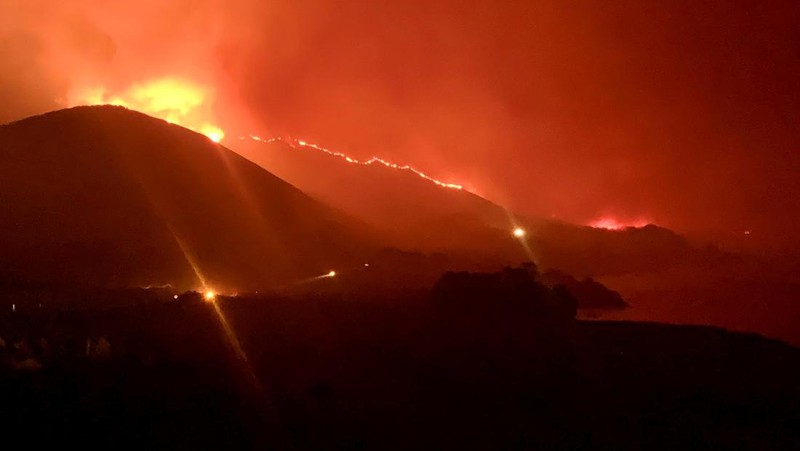 Mobil melintas saat api kebakaran Colorado membakar di sepanjang Highway 1 dekat Big Sur, California, Sabtu, 22 Januari 2022. (AP Photo/Nic Coury)