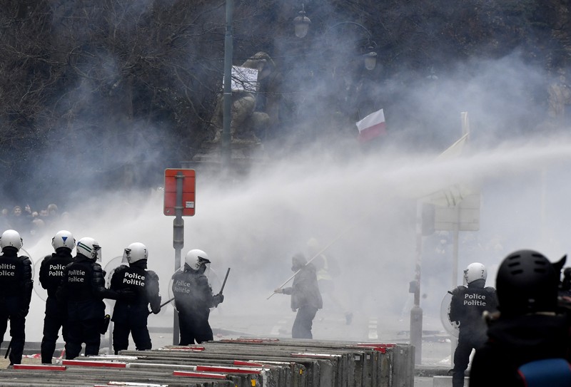 Demo Tolak Vaksin di Brussels Belgia Seorang pengunjuk rasa berbaris dengan salib di dekat markas besar Uni Eropa selama demonstrasi menentang vaksin COVID-19 di Brussels, Minggu (23/1/2022). Demonstran berkumpul di ibukota Belgia untuk memprotes apa yang mereka anggap sebagai tindakan yang terlalu ekstrem oleh pemerintah untuk memerangi COVID -19 pandemi, termasuk izin vaksin yang mengatur akses ke tempat dan kegiatan tertentu dan kemungkinan vaksin wajib. Cross berbunyi 'Kebenaran yang membuat kita dibohongi'. (AP Photo/Geert Vanden Wijngaert)