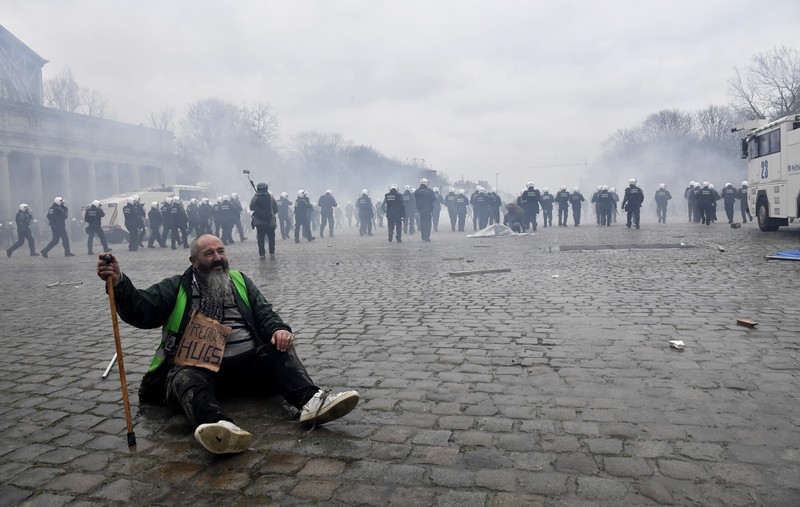Demo Tolak Vaksin di Brussels Belgia Seorang pengunjuk rasa berbaris dengan salib di dekat markas besar Uni Eropa selama demonstrasi menentang vaksin COVID-19 di Brussels, Minggu (23/1/2022). Demonstran berkumpul di ibukota Belgia untuk memprotes apa yang mereka anggap sebagai tindakan yang terlalu ekstrem oleh pemerintah untuk memerangi COVID -19 pandemi, termasuk izin vaksin yang mengatur akses ke tempat dan kegiatan tertentu dan kemungkinan vaksin wajib. Cross berbunyi 'Kebenaran yang membuat kita dibohongi'. (AP Photo/Geert Vanden Wijngaert)