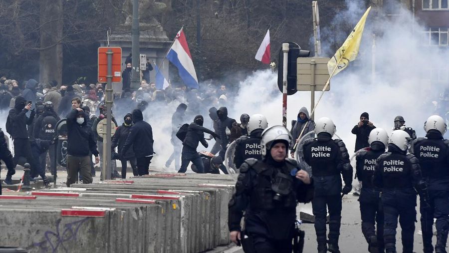 Seorang pengunjuk rasa berbaris dengan salib di dekat markas besar Uni Eropa selama demonstrasi menentang vaksin COVID-19 di Brussels, Minggu (23/1/2022). Demonstran berkumpul di ibukota Belgia untuk memprotes apa yang mereka anggap sebagai tindakan yang terlalu ekstrem oleh pemerintah untuk memerangi COVID -19 pandemi, termasuk izin vaksin yang mengatur akses ke tempat dan kegiatan tertentu dan kemungkinan vaksin wajib. Cross berbunyi 'Kebenaran yang membuat kita dibohongi'. (AP Photo/Geert Vanden Wijngaert)
