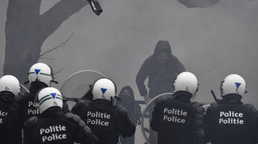 Seorang pengunjuk rasa berbaris dengan salib di dekat markas besar Uni Eropa selama demonstrasi menentang vaksin COVID-19 di Brussels, Minggu (23/1/2022). Demonstran berkumpul di ibukota Belgia untuk memprotes apa yang mereka anggap sebagai tindakan yang terlalu ekstrem oleh pemerintah untuk memerangi COVID -19 pandemi, termasuk izin vaksin yang mengatur akses ke tempat dan kegiatan tertentu dan kemungkinan vaksin wajib. Cross berbunyi 'Kebenaran yang membuat kita dibohongi'. (AP Photo/Geert Vanden Wijngaert)