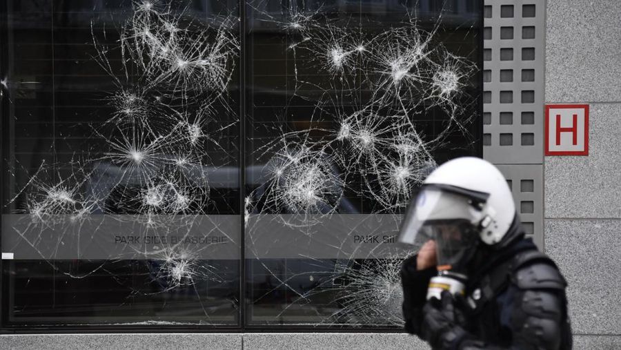 Seorang pengunjuk rasa berbaris dengan salib di dekat markas besar Uni Eropa selama demonstrasi menentang vaksin COVID-19 di Brussels, Minggu (23/1/2022). Demonstran berkumpul di ibukota Belgia untuk memprotes apa yang mereka anggap sebagai tindakan yang terlalu ekstrem oleh pemerintah untuk memerangi COVID -19 pandemi, termasuk izin vaksin yang mengatur akses ke tempat dan kegiatan tertentu dan kemungkinan vaksin wajib. Cross berbunyi 'Kebenaran yang membuat kita dibohongi'. (AP Photo/Geert Vanden Wijngaert)