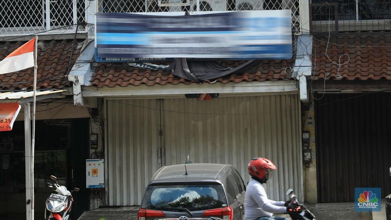 Pengendara motor melintas di depan rumah yg dijual di kawasan Kelapa Gading, Jakarta, Senin, 24/1/2022. Sektor properti di tahun 2021 lalu masih mengalami tekanan meski sudah lebih baik dari tahun 2020. Kala itu, harga tanah mengalami penurunan cukup dalam. Memasuki tahun 2022, arah perbaikan diakui mulai terlihat namun masih jauh dari normal. Pasalnya, harga-harga tanah termasuk di kawasan Kelapa Gading masih terpangkas hingga jutaan rupiah. Ketua DPC Asosiasi Real Estate Broker Indonesia (AREBI) Jakarta Utara Jopie Hori mengakui memang masih ada penurunan harga tanah. Pantauan CNBC Indonesia dilapangan beberapa toko dijual dan disewa dari berbagai macam loan properti yang berbeda. Meski dikenal kerap tergenang banjir, namun tanah atau hunian di wilayah Kelapa Gading tetap menjadi incaran banyak orang, utamanya mereka yang biasa beraktivitas di wilayah tersebut. Meski banyak dicari namun harganya tetap terkoreksi, terutama di wilayah yang paling mahal di kawasan Jakarta Utara, misalnya perumahan Bukit Gading Villa kawasan Kelapa Gading.  (CNBC Indonesia/ Muhammad Sabk)