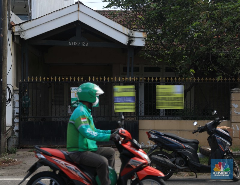 Ilsutrasi properti dijual di Kelapa Gading Pengendara motor melintas di depan rumah yg dijual di kawasan Kelapa Gading, Jakarta, Senin, 24/1/2022. Sektor properti di tahun 2021 lalu masih mengalami tekanan meski sudah lebih baik dari tahun 2020. Kala itu, harga tanah mengalami penurunan cukup dalam. Memasuki tahun 2022, arah perbaikan diakui mulai terlihat namun masih jauh dari normal. Pasalnya, harga-harga tanah termasuk di kawasan Kelapa Gading masih terpangkas hingga jutaan rupiah. Ketua DPC Asosiasi Real Estate Broker Indonesia (AREBI) Jakarta Utara Jopie Hori mengakui memang masih ada penurunan harga tanah. Pantauan CNBC Indonesia dilapangan beberapa toko dijual dan disewa dari berbagai macam loan properti yang berbeda. Meski dikenal kerap tergenang banjir, namun tanah atau hunian di wilayah Kelapa Gading tetap menjadi incaran banyak orang, utamanya mereka yang biasa beraktivitas di wilayah tersebut. Meski banyak dicari namun harganya tetap terkoreksi, terutama di wilayah yang paling mahal di kawasan Jakarta Utara, misalnya perumahan Bukit Gading Villa kawasan Kelapa Gading. (CNBC Indonesia/ Muhammad Sabk)