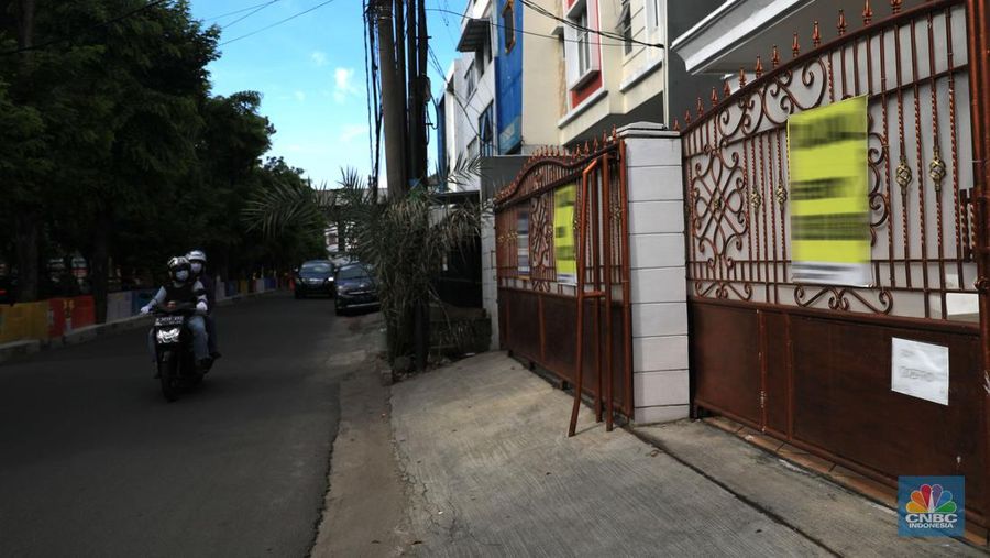 Pengendara motor melintas di depan rumah yg dijual di kawasan Kelapa Gading, Jakarta, Senin, 24/1/2022. Sektor properti di tahun 2021 lalu masih mengalami tekanan meski sudah lebih baik dari tahun 2020. Kala itu, harga tanah mengalami penurunan cukup dalam. Memasuki tahun 2022, arah perbaikan diakui mulai terlihat namun masih jauh dari normal. Pasalnya, harga-harga tanah termasuk di kawasan Kelapa Gading masih terpangkas hingga jutaan rupiah. Ketua DPC Asosiasi Real Estate Broker Indonesia (AREBI) Jakarta Utara Jopie Hori mengakui memang masih ada penurunan harga tanah. Pantauan CNBC Indonesia dilapangan beberapa toko dijual dan disewa dari berbagai macam loan properti yang berbeda. Meski dikenal kerap tergenang banjir, namun tanah atau hunian di wilayah Kelapa Gading tetap menjadi incaran banyak orang, utamanya mereka yang biasa beraktivitas di wilayah tersebut. Meski banyak dicari namun harganya tetap terkoreksi, terutama di wilayah yang paling mahal di kawasan Jakarta Utara, misalnya perumahan Bukit Gading Villa kawasan Kelapa Gading.  (CNBC Indonesia/ Muhammad Sabk)