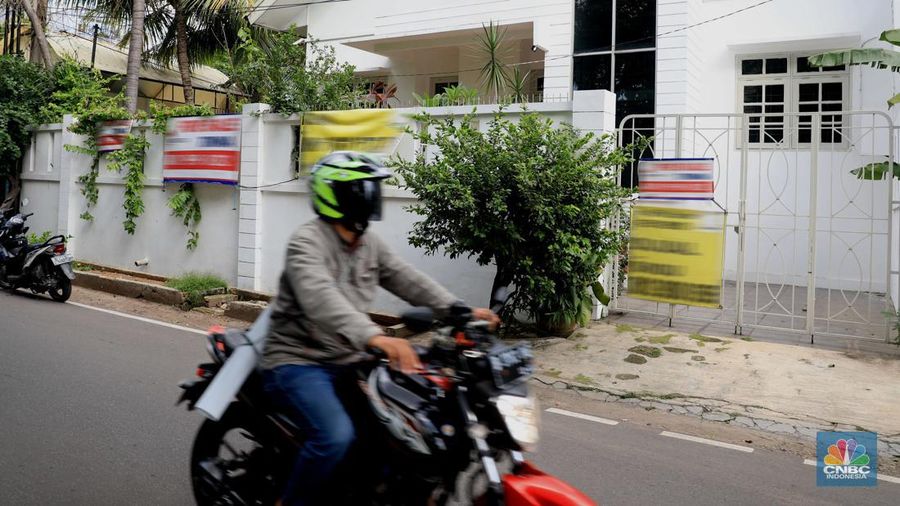 Pengendara motor melintas di depan rumah yg dijual di kawasan Kelapa Gading, Jakarta, Senin, 24/1/2022. Sektor properti di tahun 2021 lalu masih mengalami tekanan meski sudah lebih baik dari tahun 2020. Kala itu, harga tanah mengalami penurunan cukup dalam. Memasuki tahun 2022, arah perbaikan diakui mulai terlihat namun masih jauh dari normal. Pasalnya, harga-harga tanah termasuk di kawasan Kelapa Gading masih terpangkas hingga jutaan rupiah. Ketua DPC Asosiasi Real Estate Broker Indonesia (AREBI) Jakarta Utara Jopie Hori mengakui memang masih ada penurunan harga tanah. Pantauan CNBC Indonesia dilapangan beberapa toko dijual dan disewa dari berbagai macam loan properti yang berbeda. Meski dikenal kerap tergenang banjir, namun tanah atau hunian di wilayah Kelapa Gading tetap menjadi incaran banyak orang, utamanya mereka yang biasa beraktivitas di wilayah tersebut. Meski banyak dicari namun harganya tetap terkoreksi, terutama di wilayah yang paling mahal di kawasan Jakarta Utara, misalnya perumahan Bukit Gading Villa kawasan Kelapa Gading. (CNBC Indonesia/ Muhammad Sabk)