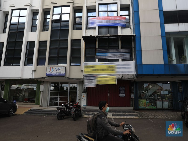 Ilsutrasi properti dijual di Kelapa Gading Pengendara motor melintas di depan rumah yg dijual di kawasan Kelapa Gading, Jakarta, Senin, 24/1/2022. Sektor properti di tahun 2021 lalu masih mengalami tekanan meski sudah lebih baik dari tahun 2020. Kala itu, harga tanah mengalami penurunan cukup dalam. Memasuki tahun 2022, arah perbaikan diakui mulai terlihat namun masih jauh dari normal. Pasalnya, harga-harga tanah termasuk di kawasan Kelapa Gading masih terpangkas hingga jutaan rupiah. Ketua DPC Asosiasi Real Estate Broker Indonesia (AREBI) Jakarta Utara Jopie Hori mengakui memang masih ada penurunan harga tanah. Pantauan CNBC Indonesia dilapangan beberapa toko dijual dan disewa dari berbagai macam loan properti yang berbeda. Meski dikenal kerap tergenang banjir, namun tanah atau hunian di wilayah Kelapa Gading tetap menjadi incaran banyak orang, utamanya mereka yang biasa beraktivitas di wilayah tersebut. Meski banyak dicari namun harganya tetap terkoreksi, terutama di wilayah yang paling mahal di kawasan Jakarta Utara, misalnya perumahan Bukit Gading Villa kawasan Kelapa Gading. (CNBC Indonesia/ Muhammad Sabk)