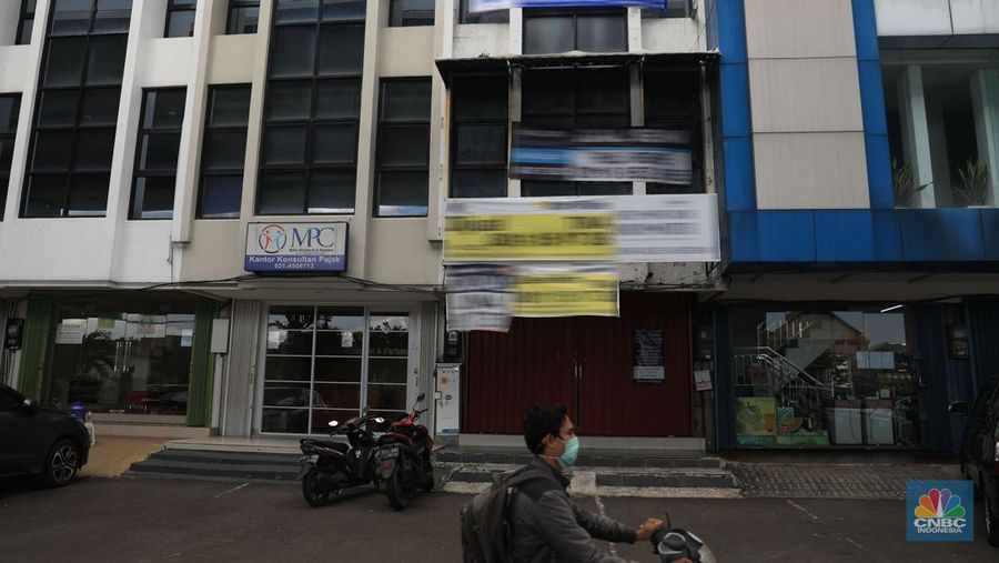 Pengendara motor melintas di depan rumah yg dijual di kawasan Kelapa Gading, Jakarta, Senin, 24/1/2022. Sektor properti di tahun 2021 lalu masih mengalami tekanan meski sudah lebih baik dari tahun 2020. Kala itu, harga tanah mengalami penurunan cukup dalam. Memasuki tahun 2022, arah perbaikan diakui mulai terlihat namun masih jauh dari normal. Pasalnya, harga-harga tanah termasuk di kawasan Kelapa Gading masih terpangkas hingga jutaan rupiah. Ketua DPC Asosiasi Real Estate Broker Indonesia (AREBI) Jakarta Utara Jopie Hori mengakui memang masih ada penurunan harga tanah. Pantauan CNBC Indonesia dilapangan beberapa toko dijual dan disewa dari berbagai macam loan properti yang berbeda. Meski dikenal kerap tergenang banjir, namun tanah atau hunian di wilayah Kelapa Gading tetap menjadi incaran banyak orang, utamanya mereka yang biasa beraktivitas di wilayah tersebut. Meski banyak dicari namun harganya tetap terkoreksi, terutama di wilayah yang paling mahal di kawasan Jakarta Utara, misalnya perumahan Bukit Gading Villa kawasan Kelapa Gading.  (CNBC Indonesia/ Muhammad Sabk)