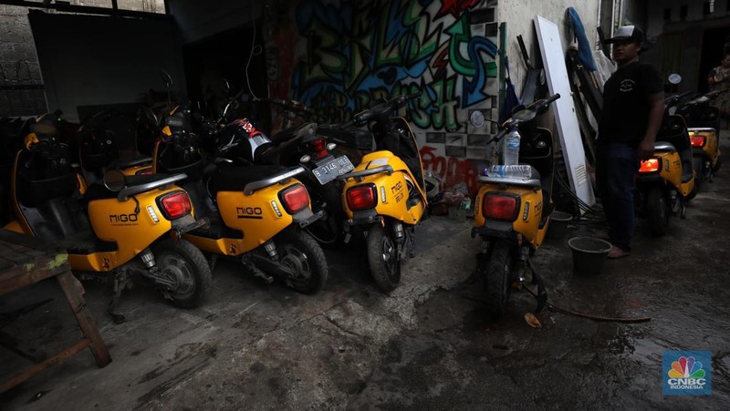 Petugas pemadam kebakaran melakukan pemadaman api yang membakar hudang rental motor listrik MIGO di kawasan  Meruya Bara, Jakarta barat, Senin (24/1/2022). Sebanyak enam mobil damkar dikerahkan dalam insiden ini. Belum ada info resmi dari pemilik gudang. Menurut warga sekitar 