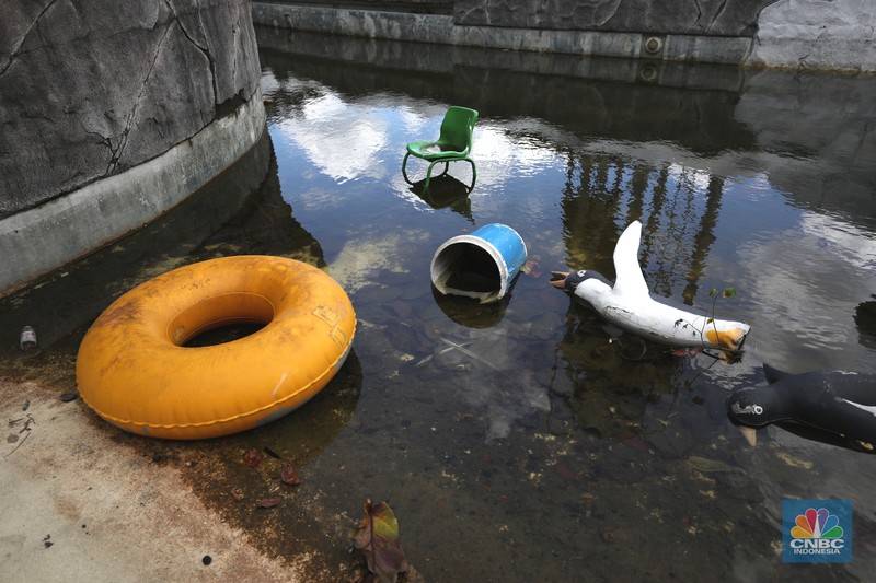 Pekerja melakukan perancangan proyek revitalisasi Taman Mini Indonesia Indah (TMII), Senin (24/1/2022). Snowbay Waterpark dulunya dikenal sebagai wahana favorit anak-anak, sayangnya karena COVID-19, kolam renang dengan berbagai wahana itu harus ditutup selama nyaris 2 tahun. Beberapa kondisi fisik yang terbengkalai terlihat dilokasi ini mulai pintu masuk tiket dan rak tempat penitipan barang. Kondisi Snowbay Waterpark saat ini memang tak terurus karena sudah lama tutup. Sejumlah kolam renang dibiarkan begitu saja hingga airnya keruh. Terlihat juga toko-toko yang dulu menjual perlengkapan renang dan kuliner juga tutup.  
Dikutip dari situs tamanmini.com, Snowbay Waterpark mulanya dirancang secara khusus sebagai taman rekreasi petualangan berkelas dunia berkonsep pegunungan salju
Taman seluas 3 hektar ini dibangun tahun 2008 dan diresmikan pembukaannya oleh ketua Yayasan harapan Kita, Hj. Siti Hardiyanti Rukmana pada tanggal 19 April 2009. Sebelumnya, taman ini adalah Taman Rekreasi Ambar Tirta. (CNBC Indonesia/ Tri Susilo)