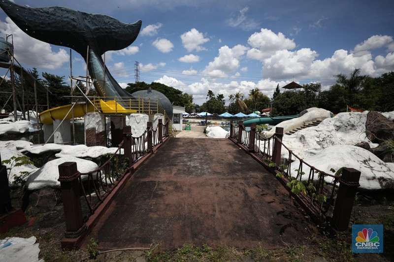 Pekerja melakukan perancangan proyek revitalisasi Taman Mini Indonesia Indah (TMII), Senin (24/1/2022). Snowbay Waterpark dulunya dikenal sebagai wahana favorit anak-anak, sayangnya karena COVID-19, kolam renang dengan berbagai wahana itu harus ditutup selama nyaris 2 tahun. Beberapa kondisi fisik yang terbengkalai terlihat dilokasi ini mulai pintu masuk tiket dan rak tempat penitipan barang. Kondisi Snowbay Waterpark saat ini memang tak terurus karena sudah lama tutup. Sejumlah kolam renang dibiarkan begitu saja hingga airnya keruh. Terlihat juga toko-toko yang dulu menjual perlengkapan renang dan kuliner juga tutup.  
Dikutip dari situs tamanmini.com, Snowbay Waterpark mulanya dirancang secara khusus sebagai taman rekreasi petualangan berkelas dunia berkonsep pegunungan salju
Taman seluas 3 hektar ini dibangun tahun 2008 dan diresmikan pembukaannya oleh ketua Yayasan harapan Kita, Hj. Siti Hardiyanti Rukmana pada tanggal 19 April 2009. Sebelumnya, taman ini adalah Taman Rekreasi Ambar Tirta. (CNBC Indonesia/ Tri Susilo)