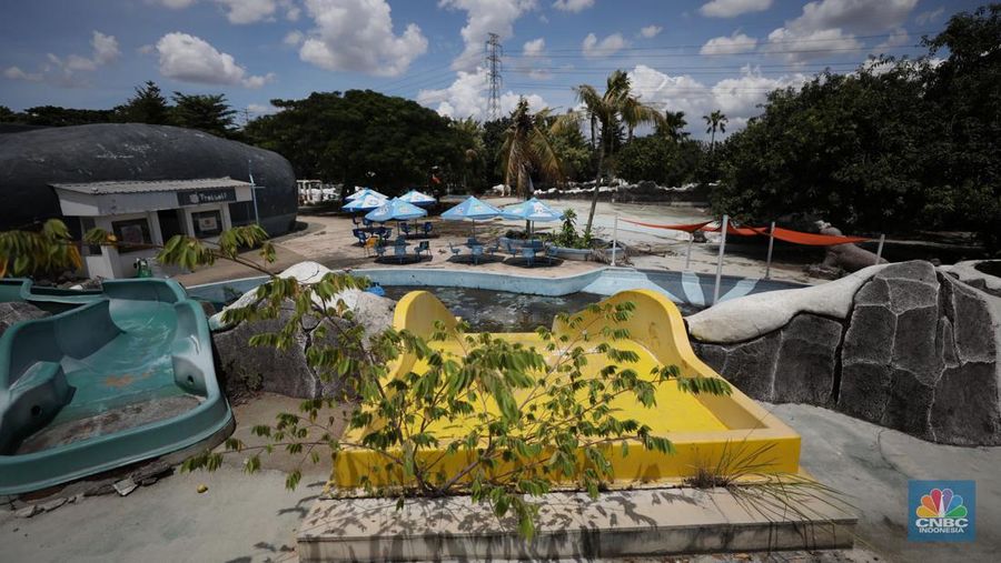 Pekerja melakukan perancangan proyek revitalisasi Taman Mini Indonesia Indah (TMII), Senin (24/1/2022). Snowbay Waterpark dulunya dikenal sebagai wahana favorit anak-anak, sayangnya karena COVID-19, kolam renang dengan berbagai wahana itu harus ditutup selama nyaris 2 tahun. Beberapa kondisi fisik yang terbengkalai terlihat dilokasi ini mulai pintu masuk tiket dan rak tempat penitipan barang. Kondisi Snowbay Waterpark saat ini memang tak terurus karena sudah lama tutup. Sejumlah kolam renang dibiarkan begitu saja hingga airnya keruh. Terlihat juga toko-toko yang dulu menjual perlengkapan renang dan kuliner juga tutup.  
Dikutip dari situs tamanmini.com, Snowbay Waterpark mulanya dirancang secara khusus sebagai taman rekreasi petualangan berkelas dunia berkonsep pegunungan salju
Taman seluas 3 hektar ini dibangun tahun 2008 dan diresmikan pembukaannya oleh ketua Yayasan harapan Kita, Hj. Siti Hardiyanti Rukmana pada tanggal 19 April 2009. Sebelumnya, taman ini adalah Taman Rekreasi Ambar Tirta. (CNBC Indonesia/ Tri Susilo)