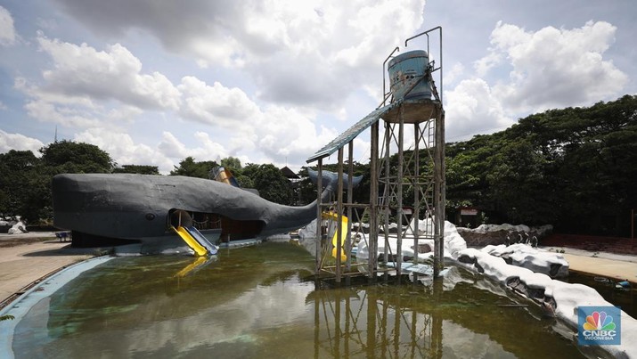 Pekerja melakukan perancangan proyek revitalisasi Taman Mini Indonesia Indah (TMII), Senin (24/1/2022). Snowbay Waterpark dulunya dikenal sebagai wahana favorit anak-anak, sayangnya karena COVID-19, kolam renang dengan berbagai wahana itu harus ditutup selama nyaris 2 tahun. Beberapa kondisi fisik yang terbengkalai terlihat dilokasi ini mulai pintu masuk tiket dan rak tempat penitipan barang. Kondisi Snowbay Waterpark saat ini memang tak terurus karena sudah lama tutup. Sejumlah kolam renang dibiarkan begitu saja hingga airnya keruh. Terlihat juga toko-toko yang dulu menjual perlengkapan renang dan kuliner juga tutup.  
Dikutip dari situs tamanmini.com, Snowbay Waterpark mulanya dirancang secara khusus sebagai taman rekreasi petualangan berkelas dunia berkonsep pegunungan salju
Taman seluas 3 hektar ini dibangun tahun 2008 dan diresmikan pembukaannya oleh ketua Yayasan harapan Kita, Hj. Siti Hardiyanti Rukmana pada tanggal 19 April 2009. Sebelumnya, taman ini adalah Taman Rekreasi Ambar Tirta. (CNBC Indonesia/ Tri Susilo)