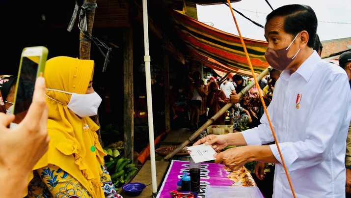 Presiden Joko Widodo (Jokowi) membagikan bantuan tunai kepada para pedagang di pasar di Pasar Baru Tanjung Enim di Kabupaten Muara Enim. (Biro Pers Sekretariat Presiden/Laily Rachev)