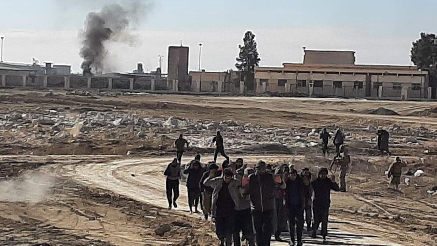 Sejumlah kelompok teroris ISIS yang menyerah setelah bentrok dengan Pasukan Demokratik Suriah pimpinan Kurdi, di Penjara Gweiran, di Hassakeh, timur laut Suriah, Senin (24/1/2022). Bentrokan antara pejuang Kurdi Suriah yang didukung AS dan kelompok teroris ISIS berlanjut untuk hari keempat Minggu di dekat penjara di timur laut Suriah yang menampung ribuan anggota ISIS, kata pasukan Kurdi. (Kurdish-led Syrian Democratic Forces, via AP)