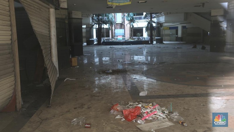 Sejumlah anak melewati bangunan Serpong Plaza yang kosong tak berpenghuni di Kawasan Jalan raya Serpong, Tangerang, Selasa (25/1/2022). 
Mall Serpong yang berada di Jalan Raya Serpong, Serpong, Tangerang Selatan ini sudah tidak digunakan dan terkesan menyeramkan.
Didepan lokasi terpasang pembatas seng dan benner bertuliskan 
