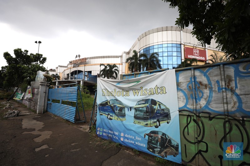 Sejumlah anak melewati bangunan Serpong Plaza yang kosong tak berpenghuni di Kawasan Jalan raya Serpong, Tangerang, Selasa (25/1/2022). 
Mall Serpong yang berada di Jalan Raya Serpong, Serpong, Tangerang Selatan ini sudah tidak digunakan dan terkesan menyeramkan.
Didepan lokasi terpasang pembatas seng dan benner bertuliskan 