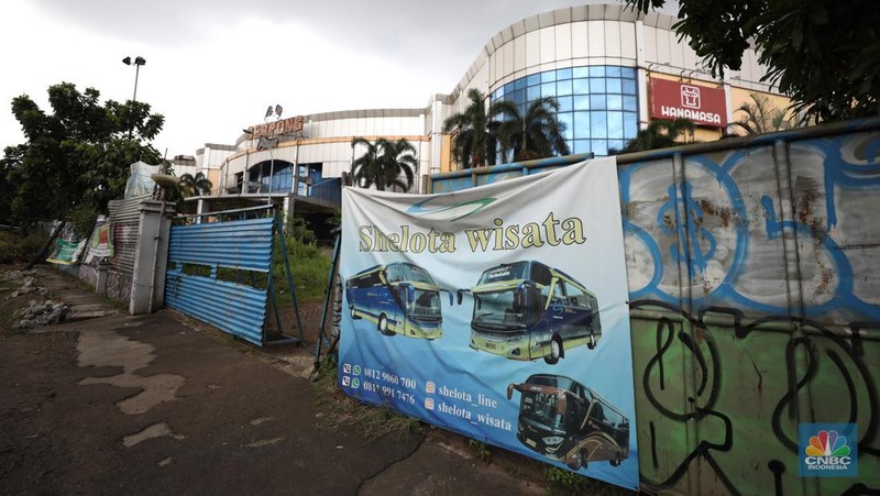 Sejumlah anak melewati bangunan Serpong Plaza yang kosong tak berpenghuni di Kawasan Jalan raya Serpong, Tangerang, Selasa (25/1/2022). 
Mall Serpong yang berada di Jalan Raya Serpong, Serpong, Tangerang Selatan ini sudah tidak digunakan dan terkesan menyeramkan.
Didepan lokasi terpasang pembatas seng dan benner bertuliskan 