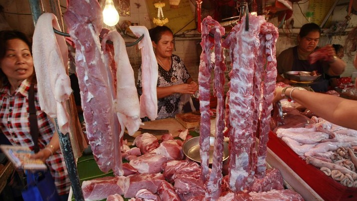 Seorang penjual daging babi (tengah)  melayani pelanggannya di tokonya di Bangkok, Thailand Sabtu (19/2/2011). (AP Photo/Apicart Weerawong)