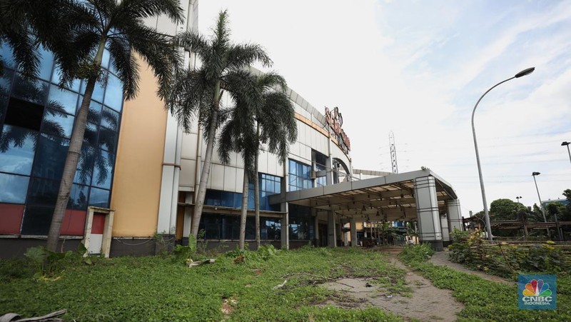 Sejumlah anak melewati bangunan Serpong Plaza yang kosong tak berpenghuni di Kawasan Jalan raya Serpong, Tangerang, Selasa (25/1/2022). 
Mall Serpong yang berada di Jalan Raya Serpong, Serpong, Tangerang Selatan ini sudah tidak digunakan dan terkesan menyeramkan.
Didepan lokasi terpasang pembatas seng dan benner bertuliskan 