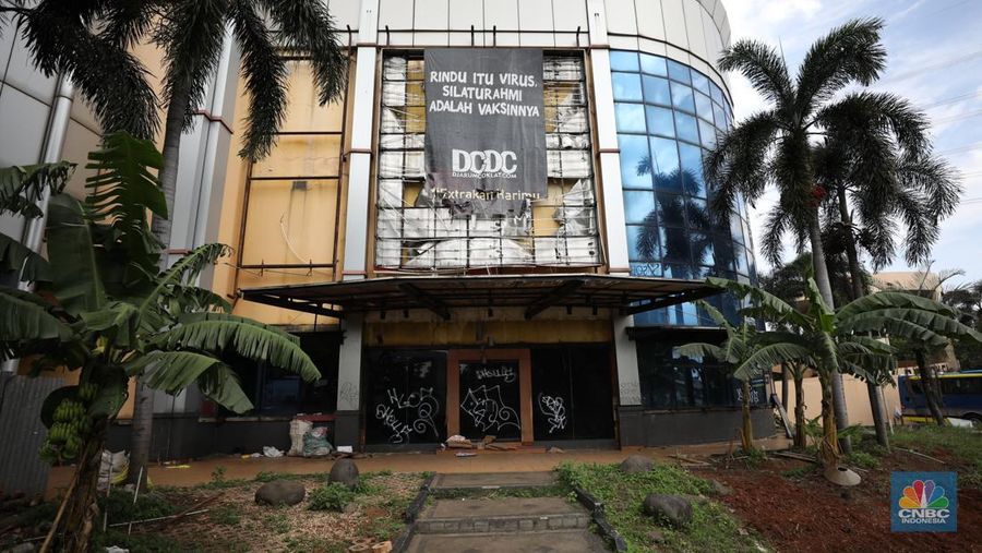Sejumlah anak melewati bangunan Serpong Plaza yang kosong tak berpenghuni di Kawasan Jalan raya Serpong, Tangerang, Selasa (25/1/2022). 
Mall Serpong yang berada di Jalan Raya Serpong, Serpong, Tangerang Selatan ini sudah tidak digunakan dan terkesan menyeramkan.
Didepan lokasi terpasang pembatas seng dan benner bertuliskan 