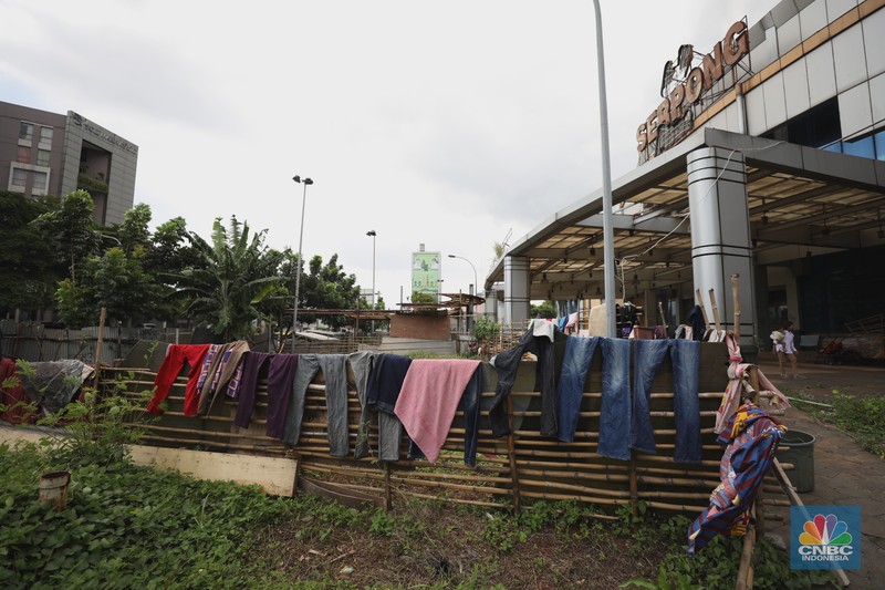 Sejumlah anak melewati bangunan Serpong Plaza yang kosong tak berpenghuni di Kawasan Jalan raya Serpong, Tangerang, Selasa (25/1/2022). 
Mall Serpong yang berada di Jalan Raya Serpong, Serpong, Tangerang Selatan ini sudah tidak digunakan dan terkesan menyeramkan.
Didepan lokasi terpasang pembatas seng dan benner bertuliskan 