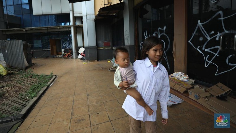 Sejumlah anak melewati bangunan Serpong Plaza yang kosong tak berpenghuni di Kawasan Jalan raya Serpong, Tangerang, Selasa (25/1/2022). 
Mall Serpong yang berada di Jalan Raya Serpong, Serpong, Tangerang Selatan ini sudah tidak digunakan dan terkesan menyeramkan.
Didepan lokasi terpasang pembatas seng dan benner bertuliskan 