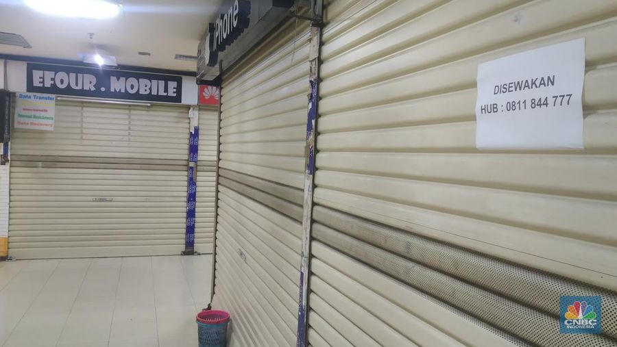 Petugas kebersihan mengepel lantai di kawasan mall Ambassador, Jakarta, Selasa, 25/1/2022. Pandemi Covid-19 telah membuat industri ritel, terutama pusat perbelanjaan sulit untuk bangkit. Mutasi baru varian Covid-19 yang terus menerus muncul membuat orang kini lebih memilih untuk tidak bepergian. Akibatnya, mal-mal di DKI Jakarta seperti di kawasan Mall Ambassador Jakarta Selatan Di mana pusat perbelanjaan tersebut kebanyakan berisi pedagang elektronik, seperti handphone, laptop, kamera, serta aksesoris lain. Kini harus menghadapi kenyataan sepi pengunjung. Banyak kini kios-kios di sejumlah pusat perbelanjaan di DKI Jakarta dijual atau disewakan.
Saat CNBC Indonesia menyambangi Mal Ambassador yang kebanyakan berisi pedagang elektronik, ada beberapa toko yang tutup di lantai 3. Terlihat pada gerai toko itu terpampang selembaran info bahwa toko tersebut hendak dijual ataupun disewakan. Meskipun pembeli terlihat cukup ramai di lantai dasar. Salah satu pedagang, Bjeh mengatakan bahwa tutupnya beberapa toko ini, karena jarangnya pembeli. Oleh karenanya pedagang harus rela meninggalkan tokonya tersebut. Berdasarkan pengamatan CNBC Indonesia, memang banyak gerai yang dijual hingga dikontrakkan ke penyewa yang berminat. Namun, itu bukan perkara mudah karena banyak pelaku usaha yang menahan dana untuk tidak berinvestasi di pusat perbelanjaan. Menanggapi fenomena mal-mal legendaris di Jakarta yang sepi, Ketua Umum Himpunan Penyewa Pusat Perbelanjaan Indonesia Budihardjo Iduansjah mengungkapkan, banyaknya tenant atau penyewa menutup gerai disebabkan ekosistem ekonomi di mal itu sudah tidak lagi bergairah. (CNBC Indonesia/ Muhammad Sabki)