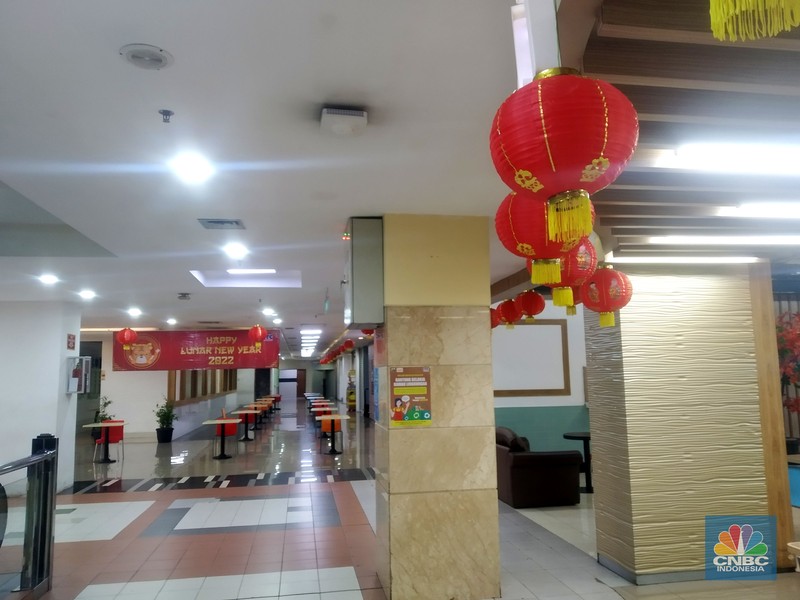 Suasana Mall Ambassador yang Sepi Petugas kebersihan mengepel lantai di kawasan mall Ambassador, Jakarta, Selasa, 25/1/2022. Pandemi Covid-19 telah membuat industri ritel, terutama pusat perbelanjaan sulit untuk bangkit. Mutasi baru varian Covid-19 yang terus menerus muncul membuat orang kini lebih memilih untuk tidak bepergian. Akibatnya, mal-mal di DKI Jakarta seperti di kawasan Mall Ambassador Jakarta Selatan Di mana pusat perbelanjaan tersebut kebanyakan berisi pedagang elektronik, seperti handphone, laptop, kamera, serta aksesoris lain. Kini harus menghadapi kenyataan sepi pengunjung. Banyak kini kios-kios di sejumlah pusat perbelanjaan di DKI Jakarta dijual atau disewakan.
Saat CNBC Indonesia menyambangi Mal Ambassador yang kebanyakan berisi pedagang elektronik, ada beberapa toko yang tutup di lantai 3. Terlihat pada gerai toko itu terpampang selembaran info bahwa toko tersebut hendak dijual ataupun disewakan. Meskipun pembeli terlihat cukup ramai di lantai dasar. Salah satu pedagang, Bjeh mengatakan bahwa tutupnya beberapa toko ini, karena jarangnya pembeli. Oleh karenanya pedagang harus rela meninggalkan tokonya tersebut. Berdasarkan pengamatan CNBC Indonesia, memang banyak gerai yang dijual hingga dikontrakkan ke penyewa yang berminat. Namun, itu bukan perkara mudah karena banyak pelaku usaha yang menahan dana untuk tidak berinvestasi di pusat perbelanjaan. Menanggapi fenomena mal-mal legendaris di Jakarta yang sepi, Ketua Umum Himpunan Penyewa Pusat Perbelanjaan Indonesia Budihardjo Iduansjah mengungkapkan, banyaknya tenant atau penyewa menutup gerai disebabkan ekosistem ekonomi di mal itu sudah tidak lagi bergairah. (CNBC Indonesia/ Muhammad Sabki)