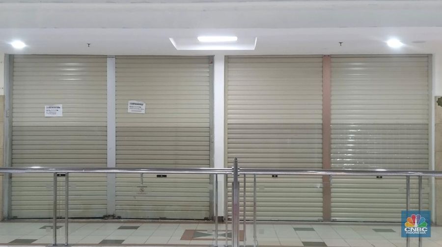 Petugas kebersihan mengepel lantai di kawasan mall Ambassador, Jakarta, Selasa, 25/1/2022. Pandemi Covid-19 telah membuat industri ritel, terutama pusat perbelanjaan sulit untuk bangkit. Mutasi baru varian Covid-19 yang terus menerus muncul membuat orang kini lebih memilih untuk tidak bepergian. Akibatnya, mal-mal di DKI Jakarta seperti di kawasan Mall Ambassador Jakarta Selatan Di mana pusat perbelanjaan tersebut kebanyakan berisi pedagang elektronik, seperti handphone, laptop, kamera, serta aksesoris lain. Kini harus menghadapi kenyataan sepi pengunjung. Banyak kini kios-kios di sejumlah pusat perbelanjaan di DKI Jakarta dijual atau disewakan.
Saat CNBC Indonesia menyambangi Mal Ambassador yang kebanyakan berisi pedagang elektronik, ada beberapa toko yang tutup di lantai 3. Terlihat pada gerai toko itu terpampang selembaran info bahwa toko tersebut hendak dijual ataupun disewakan. Meskipun pembeli terlihat cukup ramai di lantai dasar. Salah satu pedagang, Bjeh mengatakan bahwa tutupnya beberapa toko ini, karena jarangnya pembeli. Oleh karenanya pedagang harus rela meninggalkan tokonya tersebut. Berdasarkan pengamatan CNBC Indonesia, memang banyak gerai yang dijual hingga dikontrakkan ke penyewa yang berminat. Namun, itu bukan perkara mudah karena banyak pelaku usaha yang menahan dana untuk tidak berinvestasi di pusat perbelanjaan. Menanggapi fenomena mal-mal legendaris di Jakarta yang sepi, Ketua Umum Himpunan Penyewa Pusat Perbelanjaan Indonesia Budihardjo Iduansjah mengungkapkan, banyaknya tenant atau penyewa menutup gerai disebabkan ekosistem ekonomi di mal itu sudah tidak lagi bergairah. (CNBC Indonesia/ Muhammad Sabki)