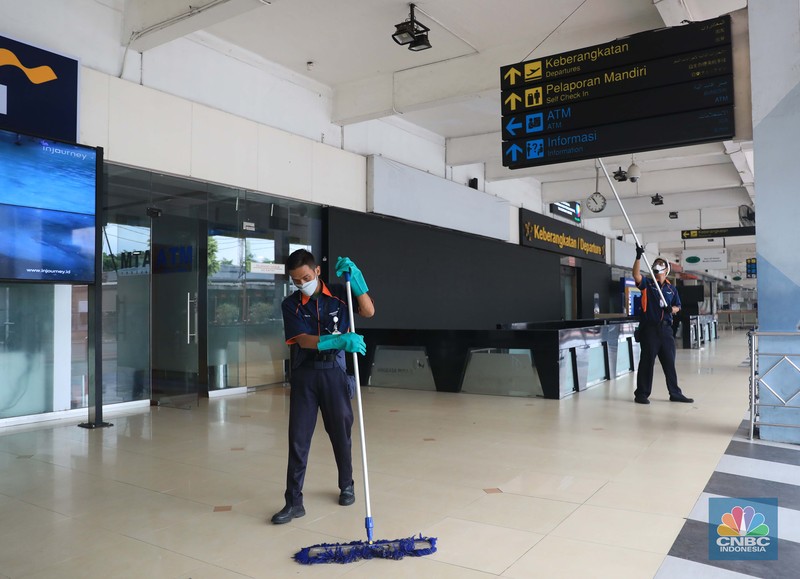 Suasana Bandara Halim Perdanakusuma Saat Penutupan Sementara, Rabu (26/1/2022). Petugas kebersihan membersihkan area di Bandara Halim, Jakarta, Rabu, 26/1/2022. Bandara Halim Perdanakusuma ditutup sementara selama 3,5 bulan mulai 26 Januari 2022. Perpindahan operasional penerbangan pun dilakukan ke 5 bandara penerima. Pantauan CNBC Indonesia di lokasi pukul 09.45 WIB, tampak lobi bandara sepi pengunjung. Di sana hanya terlihat beberapa petugas bandara dan maskapai. Dilokasi tersebut masih ada pelayanan informasi jika calon penumpang masih ada yang datang di Bandara Halim. Sejumlah petugas kebersihan tampak sedang membersihkan area lobi bandara, mulai lantai hingga kursi. Beberapa ruko di samping lobi bandara terlihat tutup, sebagian masih ada yang buka. Sebelumnya, juru bicara Kementerian Perhubungan Adita Irawati mengatakan revitalisasi Bandara Halim dilakukan untuk memperbaiki fasilitas sisi darat maupun udara. Juga dalam rangka meningkatkan aspek keselamatan, keamanan, dan kenyamanan penerbangan. Adapun pekerjaan yang akan dilakukan adalah pembangunan di sisi udara maupun sisi darat, yakni meliputi penyehatan landas pacu (runway) dan landas hubung (taxiway), dan peningkatan kapasitas landas parkir (apron) pesawat udara naratetama (VVIP) dan naratama (VIP). Selain itu, dilakukan renovasi gedung naratetama dan naratama, renovasi bangunan operasi, perbaikan sistem drainase di dalam bandar udara dan penataan fasilitas lainnya. (CNBC Indonesia/ Muhammad Sabki)