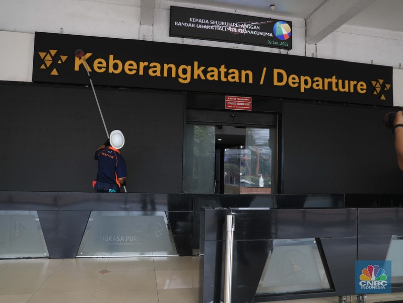 Suasana Bandara Halim Perdanakusuma Saat Penutupan Sementara, Rabu (26/1/2022). Petugas kebersihan membersihkan area di Bandara Halim, Jakarta, Rabu, 26/1/2022. Bandara Halim Perdanakusuma ditutup sementara selama 3,5 bulan mulai 26 Januari 2022. Perpindahan operasional penerbangan pun dilakukan ke 5 bandara penerima. Pantauan CNBC Indonesia di lokasi pukul 09.45 WIB, tampak lobi bandara sepi pengunjung. Di sana hanya terlihat beberapa petugas bandara dan maskapai. Dilokasi tersebut masih ada pelayanan informasi jika calon penumpang masih ada yang datang di Bandara Halim. Sejumlah petugas kebersihan tampak sedang membersihkan area lobi bandara, mulai lantai hingga kursi. Beberapa ruko di samping lobi bandara terlihat tutup, sebagian masih ada yang buka. Sebelumnya, juru bicara Kementerian Perhubungan Adita Irawati mengatakan revitalisasi Bandara Halim dilakukan untuk memperbaiki fasilitas sisi darat maupun udara. Juga dalam rangka meningkatkan aspek keselamatan, keamanan, dan kenyamanan penerbangan. Adapun pekerjaan yang akan dilakukan adalah pembangunan di sisi udara maupun sisi darat, yakni meliputi penyehatan landas pacu (runway) dan landas hubung (taxiway), dan peningkatan kapasitas landas parkir (apron) pesawat udara naratetama (VVIP) dan naratama (VIP). Selain itu, dilakukan renovasi gedung naratetama dan naratama, renovasi bangunan operasi, perbaikan sistem drainase di dalam bandar udara dan penataan fasilitas lainnya. (CNBC Indonesia/ Muhammad Sabki)