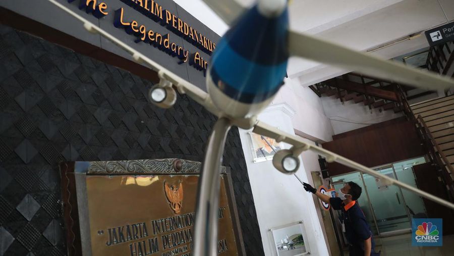 Petugas kebersihan membersihkan area di Bandara Halim, Jakarta, Rabu, 26/1/2022. Bandara Halim Perdanakusuma ditutup sementara selama 3,5 bulan mulai 26 Januari 2022. Perpindahan operasional penerbangan pun dilakukan ke 5 bandara penerima. Pantauan CNBC Indonesia di lokasi pukul 09.45 WIB, tampak lobi bandara sepi pengunjung. Di sana hanya terlihat beberapa petugas bandara dan maskapai. Dilokasi tersebut masih ada pelayanan informasi jika calon penumpang masih ada yang datang di Bandara Halim. Sejumlah petugas kebersihan tampak sedang membersihkan area lobi bandara, mulai lantai hingga kursi. Beberapa ruko di samping lobi bandara terlihat tutup, sebagian masih ada yang buka. Sebelumnya, juru bicara Kementerian Perhubungan Adita Irawati mengatakan revitalisasi Bandara Halim dilakukan untuk memperbaiki fasilitas sisi darat maupun udara. Juga dalam rangka meningkatkan aspek keselamatan, keamanan, dan kenyamanan penerbangan. Adapun pekerjaan yang akan dilakukan adalah pembangunan di sisi udara maupun sisi darat, yakni meliputi penyehatan landas pacu (runway) dan landas hubung (taxiway), dan peningkatan kapasitas landas parkir (apron) pesawat udara naratetama (VVIP) dan naratama (VIP). Selain itu, dilakukan renovasi gedung naratetama dan naratama, renovasi bangunan operasi, perbaikan sistem drainase di dalam bandar udara dan penataan fasilitas lainnya. (CNBC Indonesia/ Muhammad Sabki)