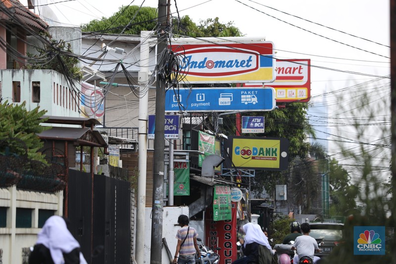 Alfamart dan Indomaret Sejumlah warga melewati toko Indomaret dan Alfamart yang berlokasi di Sukabumi Utara, Jakarta Barat, Kamis (27/1/2022). Indomaret dan Alfamart mungkin terlihat selalu berdekatan yang memiliki banyak persamaan. Namun, keduanya mengakui bahwa mereka memiliki keunggulannya masing-masing. Ada yang mengusung keunggulan dari segi harga lebih murah, kapasitas toko lebih luas, pelayanan lebih ramah atau kenyamanan suasana. Pantauan dilokasi Indomaret dan Alfamart berdekatan dan bersampingan berlada di berbagai lokasi contohnya, Petukangan Utara, Kreo, Duri Kosambi dan Kebon Jeruk. (CNBC Indonesia/Tri Susilo)