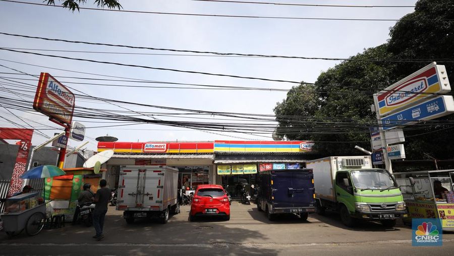 Sejumlah warga melewati toko Indomaret dan Alfamart yang berlokasi di Sukabumi Utara, Jakarta Barat, Kamis (27/1/2022). Indomaret dan Alfamart mungkin terlihat selalu berdekatan yang memiliki banyak persamaan. Namun, keduanya mengakui bahwa mereka memiliki keunggulannya masing-masing. Ada yang mengusung keunggulan dari segi harga lebih murah, kapasitas toko lebih luas, pelayanan lebih ramah atau kenyamanan suasana. Pantauan dilokasi Indomaret dan Alfamart berdekatan dan bersampingan berlada di berbagai lokasi contohnya, Petukangan Utara, Kreo, Duri Kosambi dan Kebon Jeruk. (CNBC Indonesia/Tri Susilo)