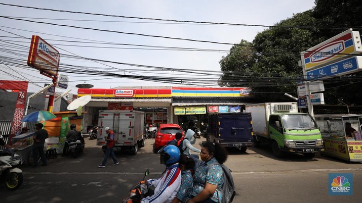 Sejumlah warga melewati toko Indomaret dan Alfamart yang berlokasi di Sukabumi Utara, Jakarta Barat, Kamis (27/1/2022). Indomaret dan Alfamart mungkin terlihat selalu berdekatan yang memiliki banyak persamaan. Namun, keduanya mengakui bahwa mereka memiliki keunggulannya masing-masing. Ada yang mengusung keunggulan dari segi harga lebih murah, kapasitas toko lebih luas, pelayanan lebih ramah atau kenyamanan suasana. Pantauan dilokasi Indomaret dan Alfamart berdekatan dan bersampingan berlada di berbagai lokasi contohnya, Petukangan Utara, Kreo, Duri Kosambi dan Kebon Jeruk. (CNBC Indonesia/Tri Susilo)