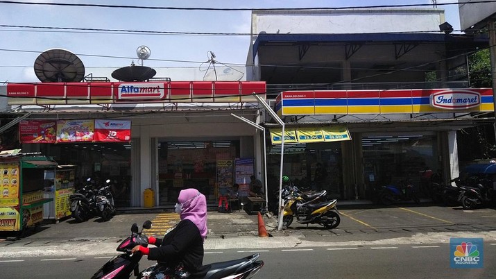 Sejumlah warga melewati toko Indomaret dan Alfamart yang berlokasi di Sukabumi Utara, Jakarta Barat, Kamis (27/1/2022). Indomaret dan Alfamart mungkin terlihat selalu berdekatan yang memiliki banyak persamaan. Namun, keduanya mengakui bahwa mereka memiliki keunggulannya masing-masing. Ada yang mengusung keunggulan dari segi harga lebih murah, kapasitas toko lebih luas, pelayanan lebih ramah atau kenyamanan suasana. Pantauan dilokasi Indomaret dan Alfamart berdekatan dan bersampingan berlada di berbagai lokasi contohnya, Petukangan Utara, Kreo, Duri Kosambi dan Kebon Jeruk. (CNBC Indonesia/Tri Susilo)